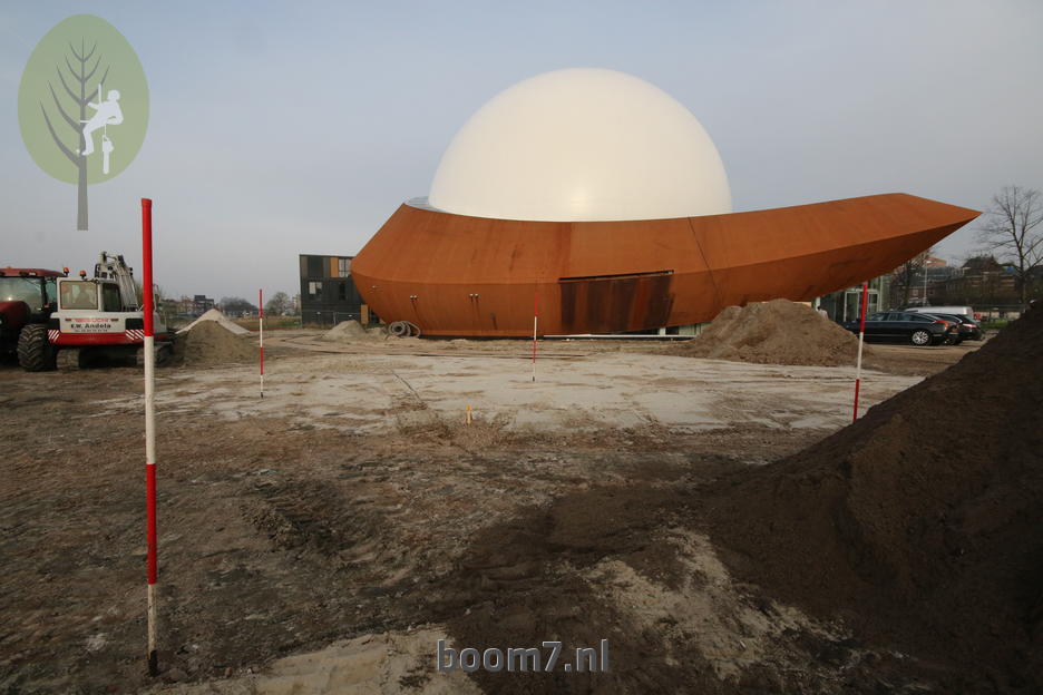 de palen geven aan waar gegraven moet worden om het pallet met boom te plaatsen